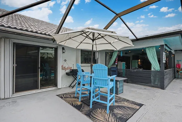 a view of patio with chairs and table under an umbrella