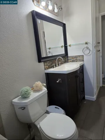 a bathroom with a toilet a sink and mirror
