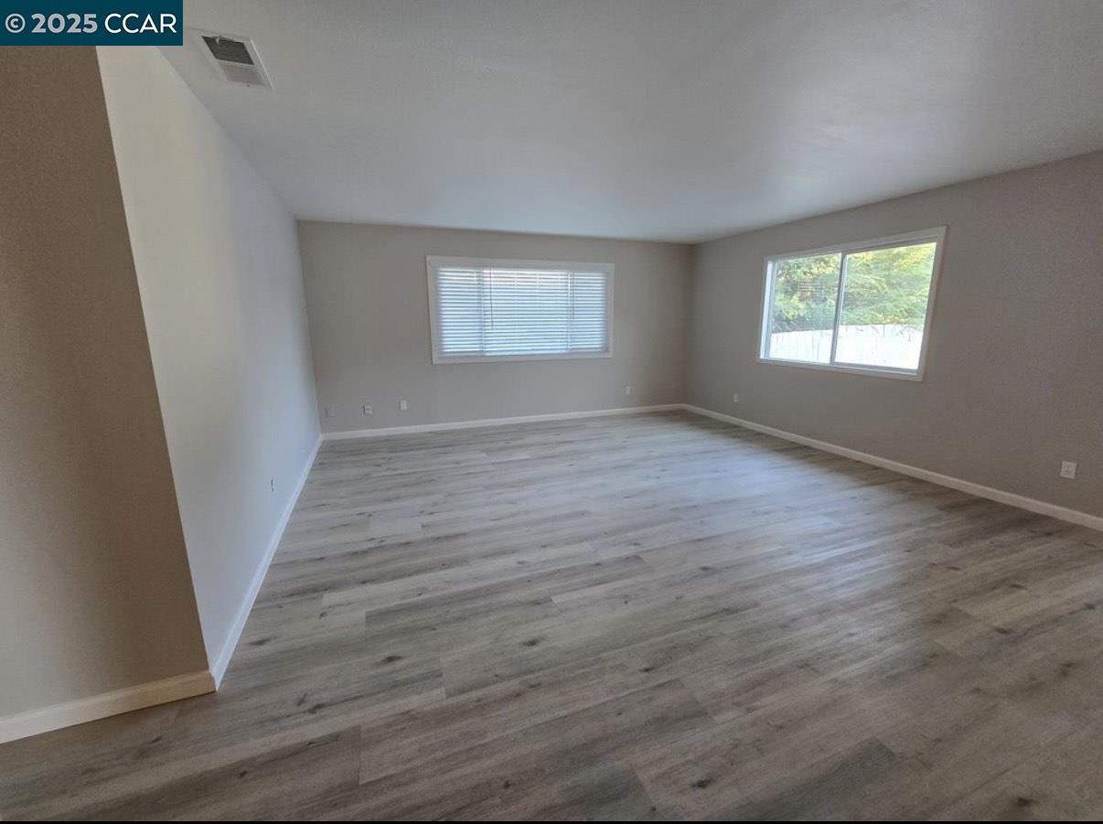 4340 Balfour Road Brentwood, CA 94513 - Photo 9 of 21 an empty room with wooden floor and windows