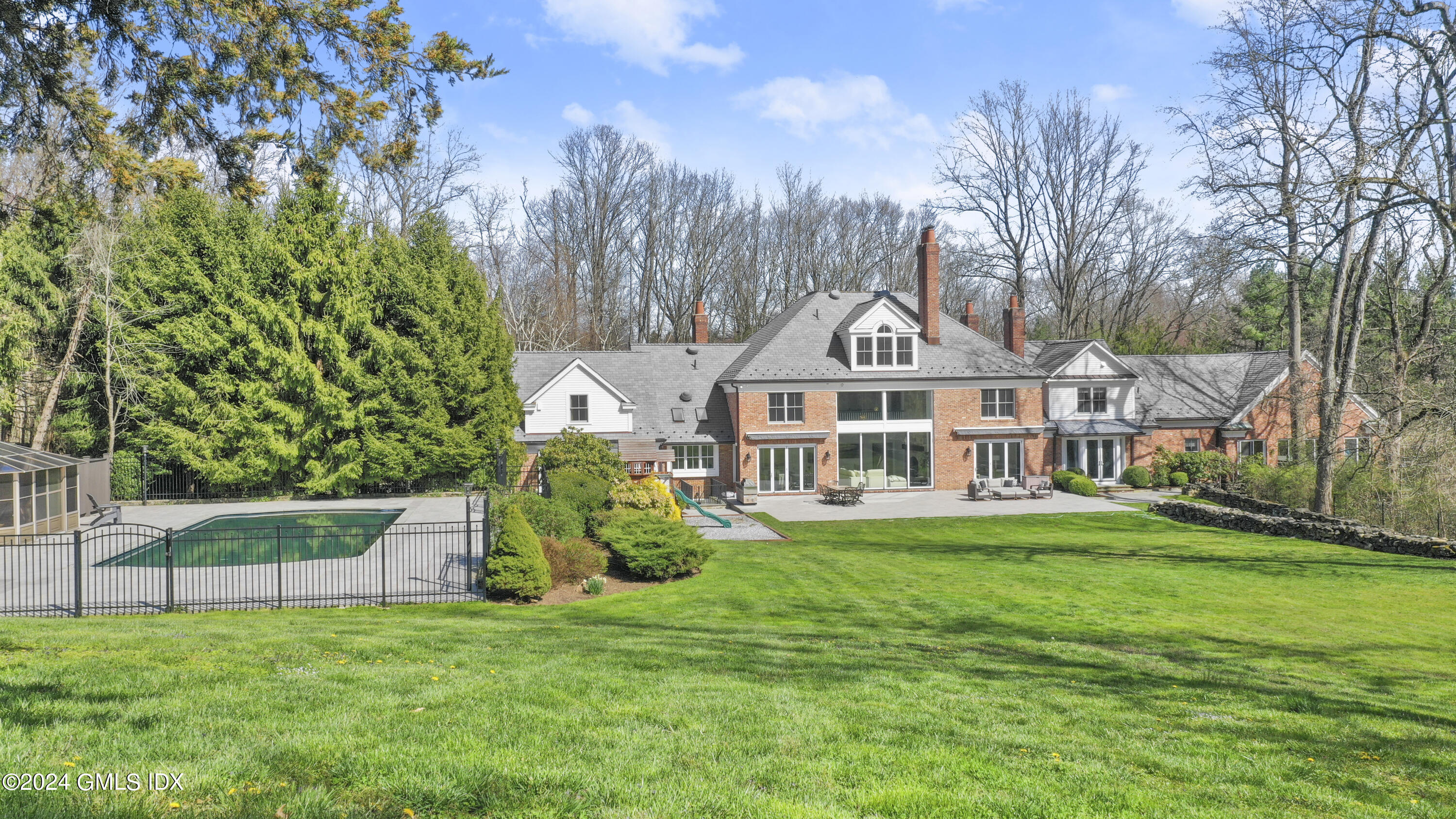 24 Highland Farm Road Greenwich, CT 06831 - Photo 5 of 34 a front view of a house with a garden