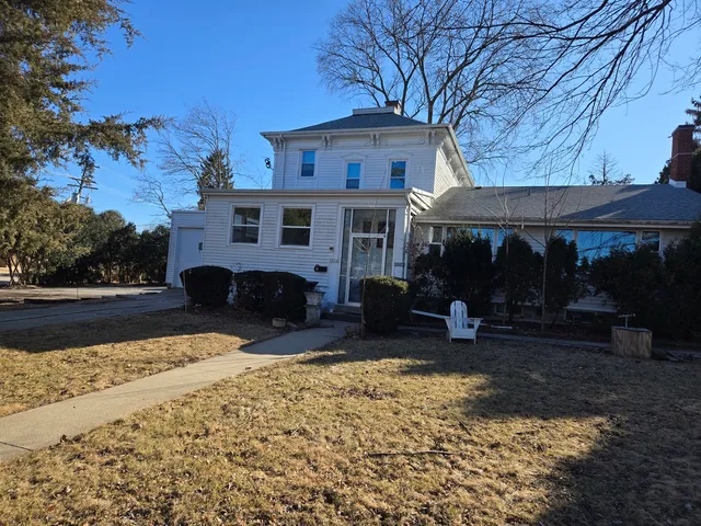 a view of a house with backyard and sitting area