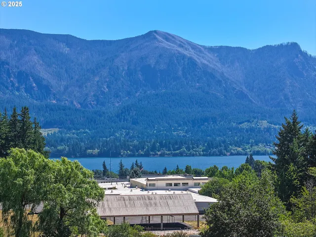 a view of a house with a yard and a car park
