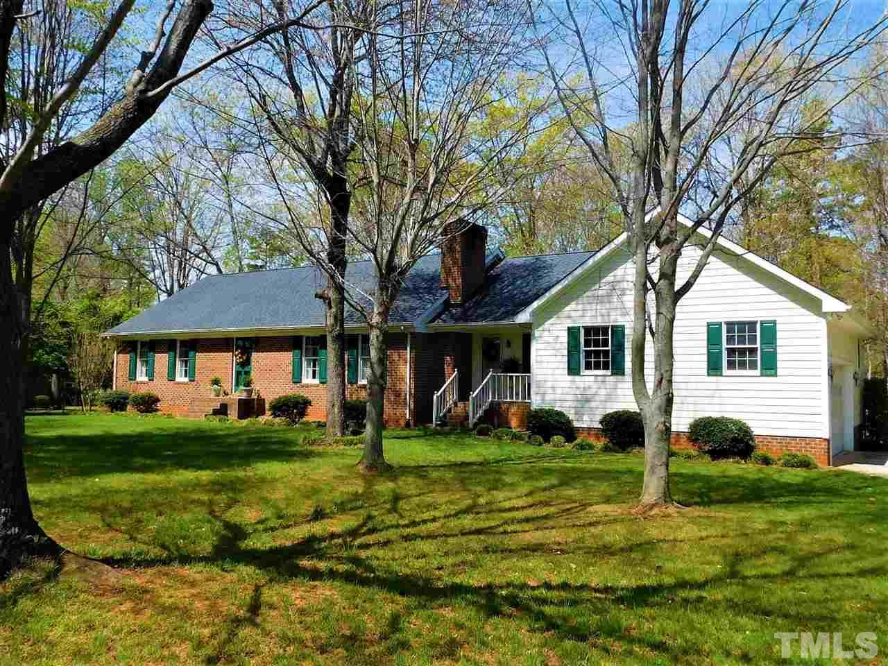 2176 Burlington Road Roxboro, NC 27573 - Photo 1 of 25 a view of a white house in front of a big yard with large trees