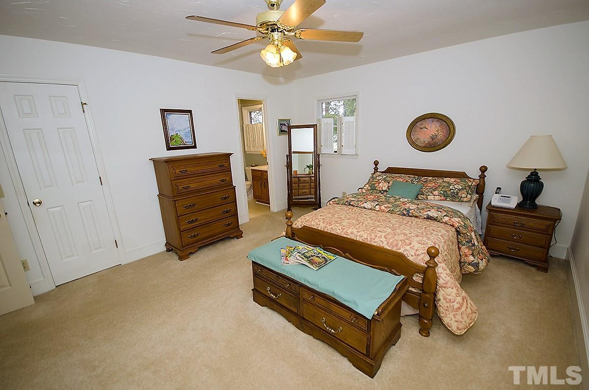 2176 Burlington Road Roxboro, NC 27573 - Photo 14 of 25 a bedroom with a bed and a chandelier