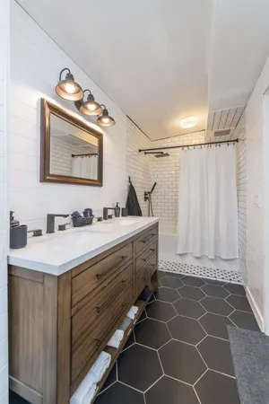 a bathroom with a sink mirror and a shower