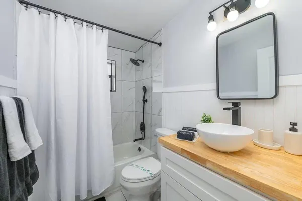 a bathroom with a granite countertop sink toilet and shower