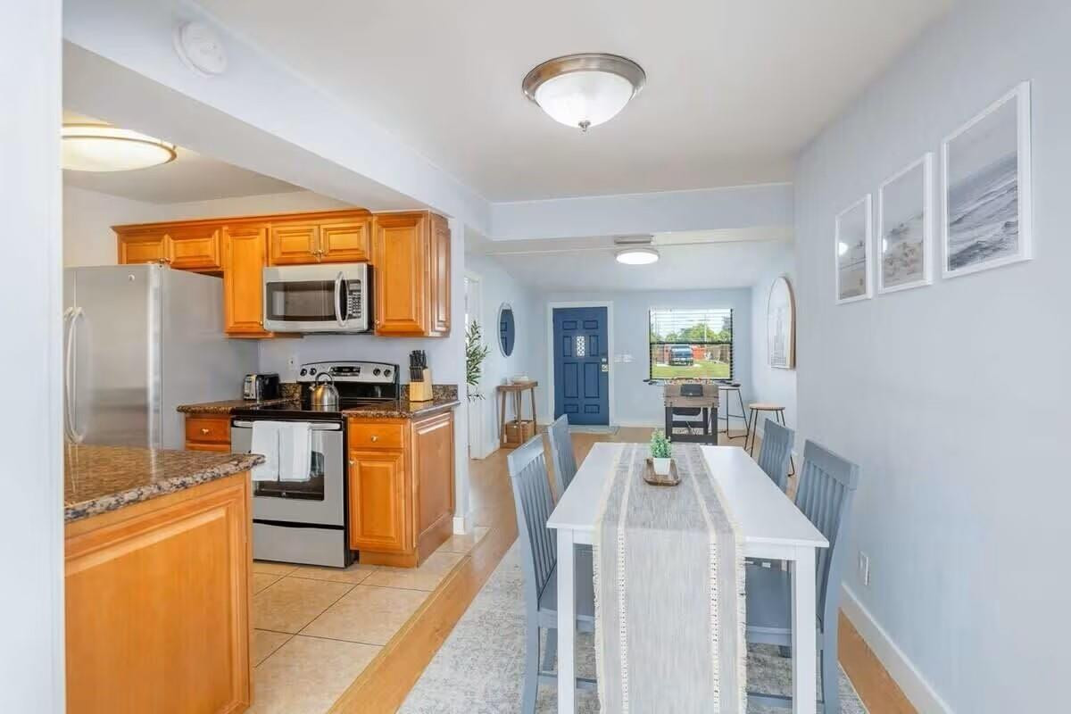 3762 Catalina Road West Palm Beach, FL 33410 - Photo 3 of 29 a kitchen with stainless steel appliances kitchen island granite countertop a refrigerator a stove and a sink with cabinets