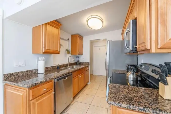 a kitchen with stainless steel appliances granite countertop a stove a sink and a microwave