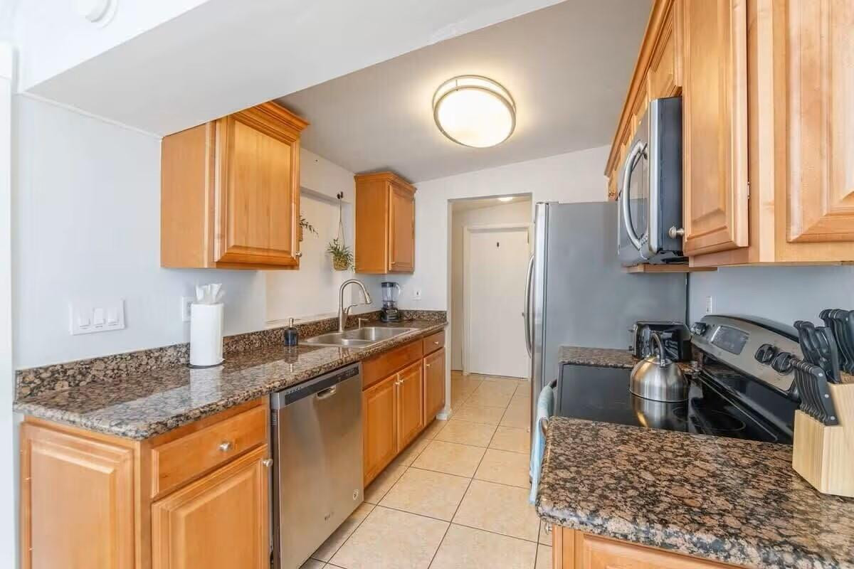 3762 Catalina Road West Palm Beach, FL 33410 - Photo 5 of 29 a kitchen with stainless steel appliances granite countertop a stove a sink and a microwave