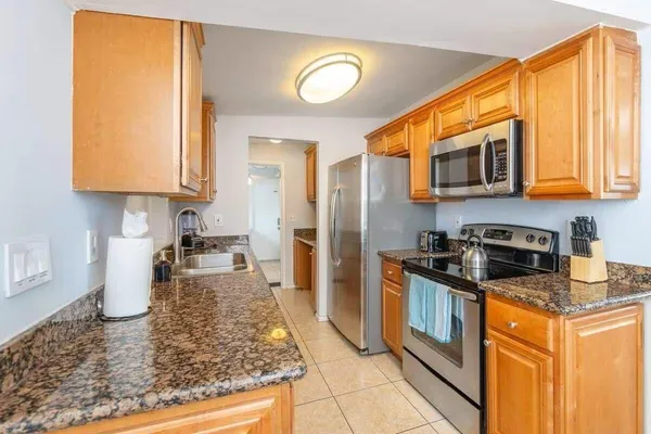 a kitchen with stainless steel appliances granite countertop a stove a sink and a microwave