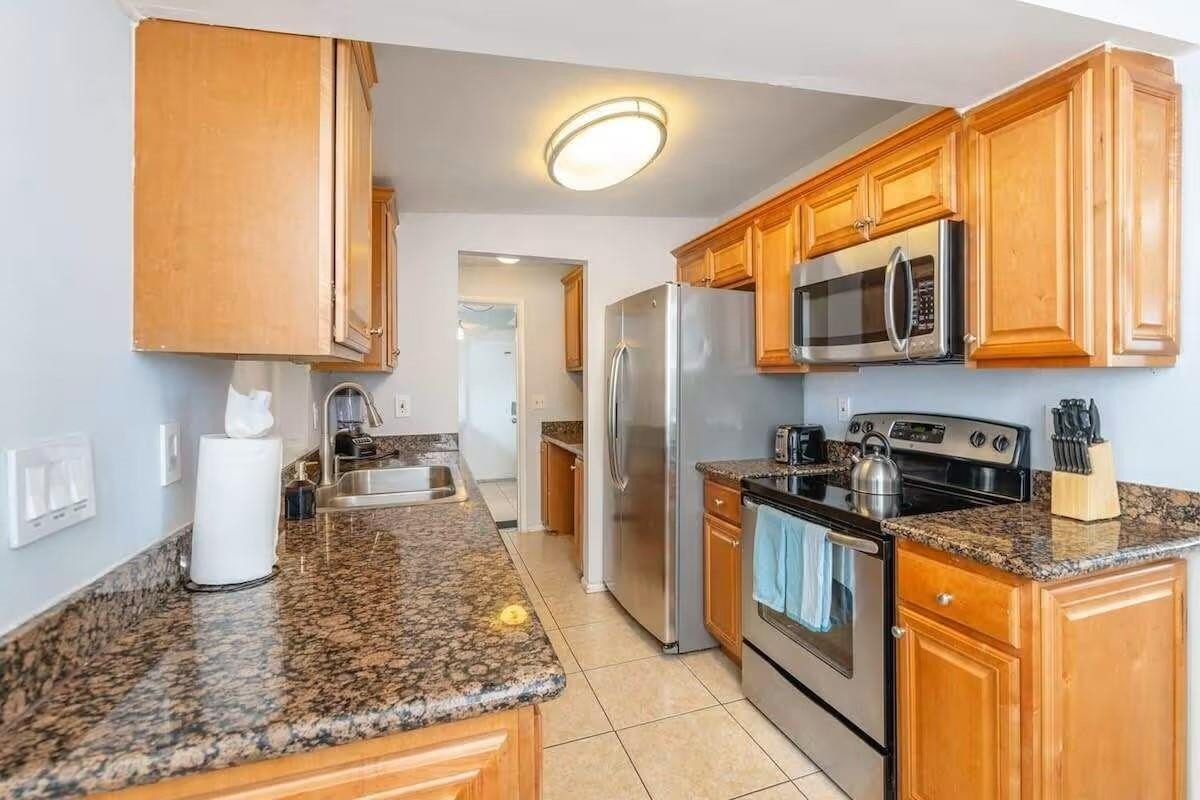 3762 Catalina Road West Palm Beach, FL 33410 - Photo 6 of 29 a kitchen with stainless steel appliances granite countertop a stove a sink and a microwave