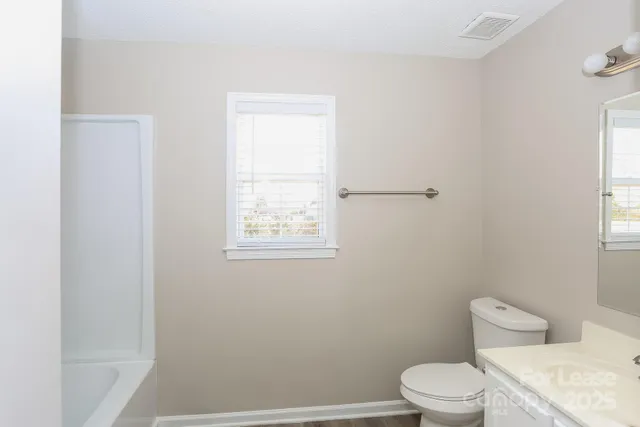 a white toilet sitting next to a window