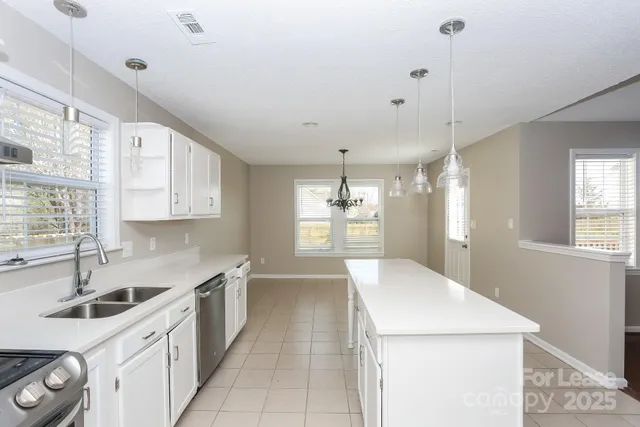 a kitchen with a sink a stove and cabinets