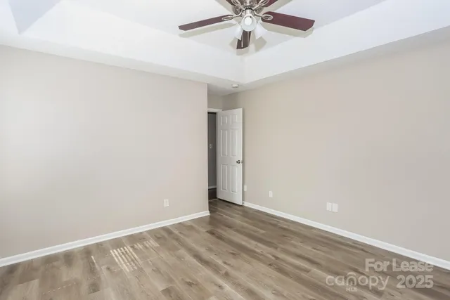 an empty room with a window and a fan