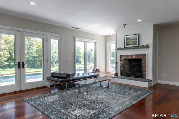 a living room with fireplace furniture and a rug