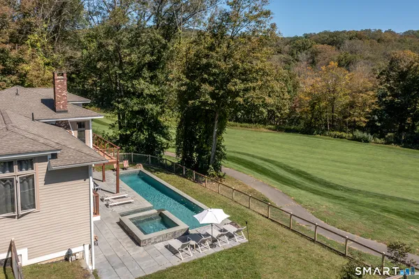 a view of a house with a big yard and large trees