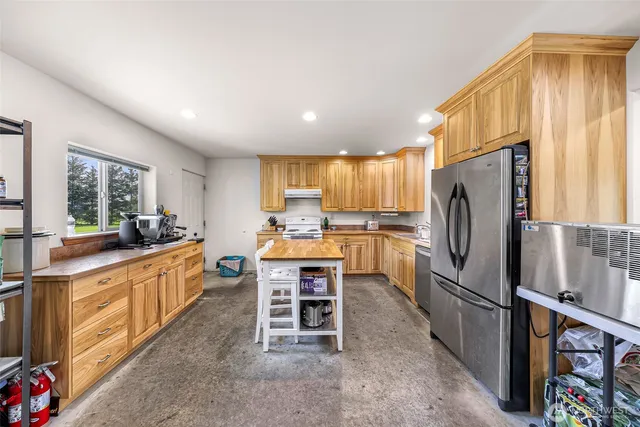 a utility room with stainless steel appliances granite countertop a stove and cabinets