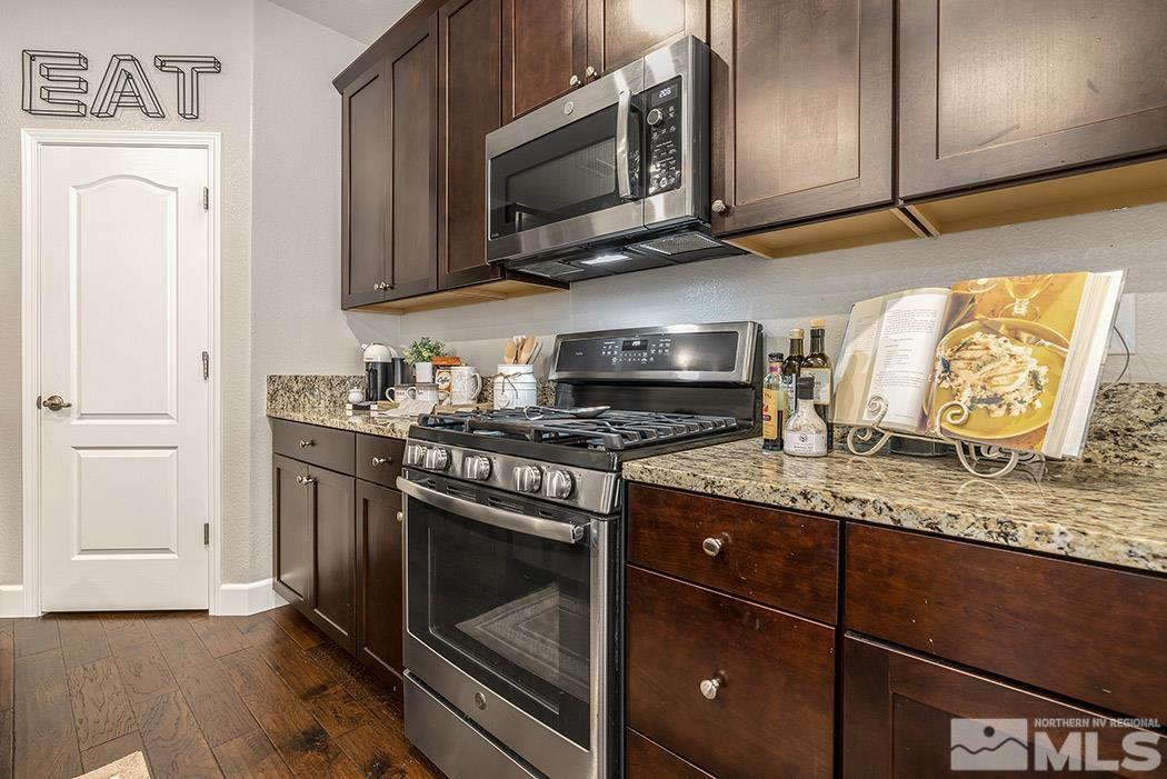 1880 Toltec Trail Reno, NV 89521 - Photo 8 of 24 a kitchen with stainless steel appliances granite countertop a stove a microwave and cabinets