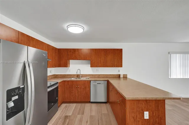 a kitchen with wooden floors and wooden cabinets