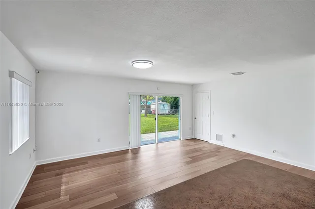 a view of an empty room with a sink and a window