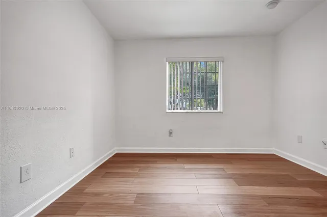 a view of a room with wooden floor and a window
