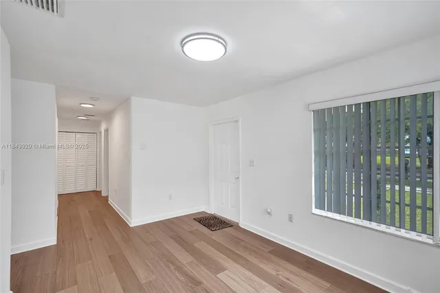 a view of a room with wooden floor and windows