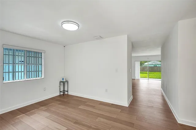 wooden floor in an empty room with a window