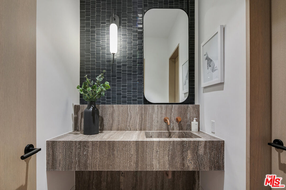 5376 Round Meadow Road Hidden Hills, CA 91302 - Photo 26 of 31 a bathroom with a sink and a mirror
