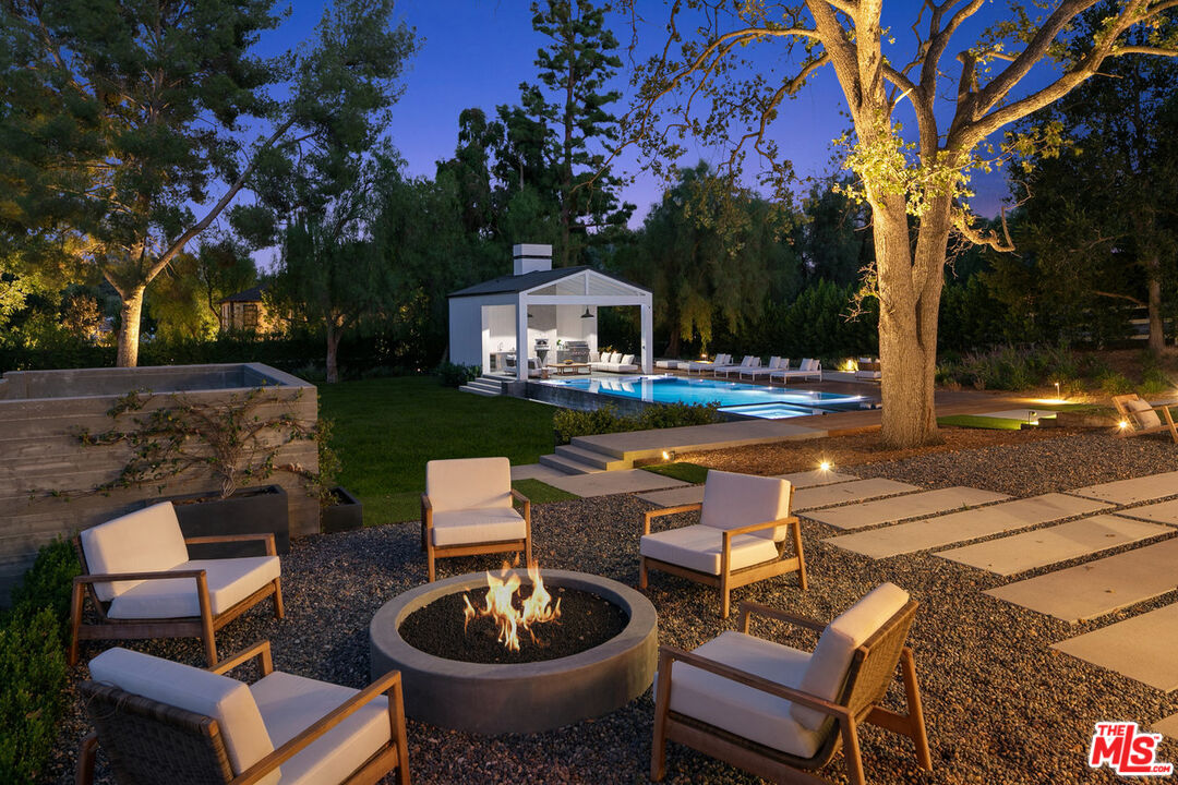 5376 Round Meadow Road Hidden Hills, CA 91302 - Photo 29 of 31 a view of a patio with table and chairs and a fire pit