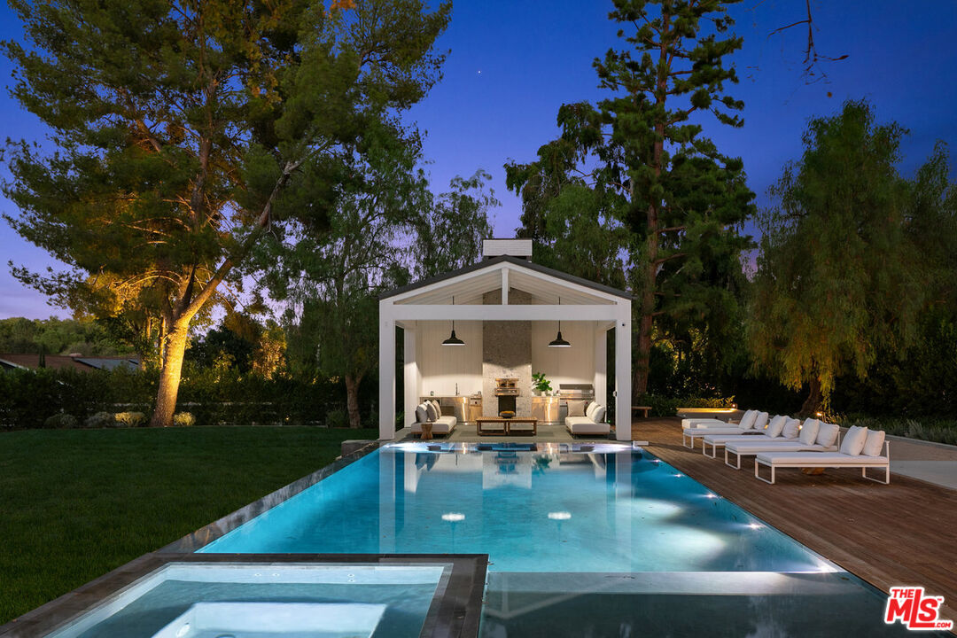 5376 Round Meadow Road Hidden Hills, CA 91302 - Photo 30 of 31 a view of a patio with dining table and chairs with a fire pit and a large tree