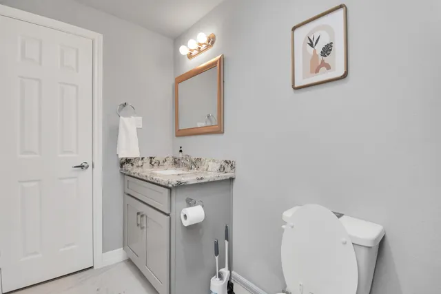 a bathroom with a toilet sink and mirror