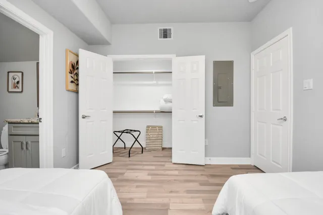 a bedroom with a bed and closet with wooden floor