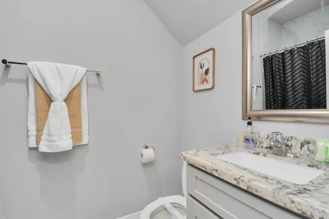 a bathroom with a granite countertop sink and a mirror