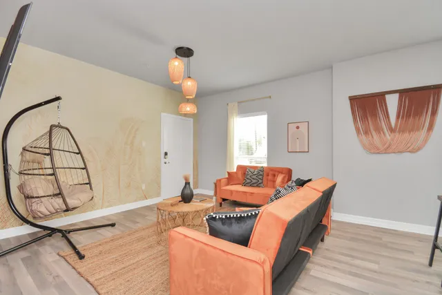 a living room with furniture and a wooden floor