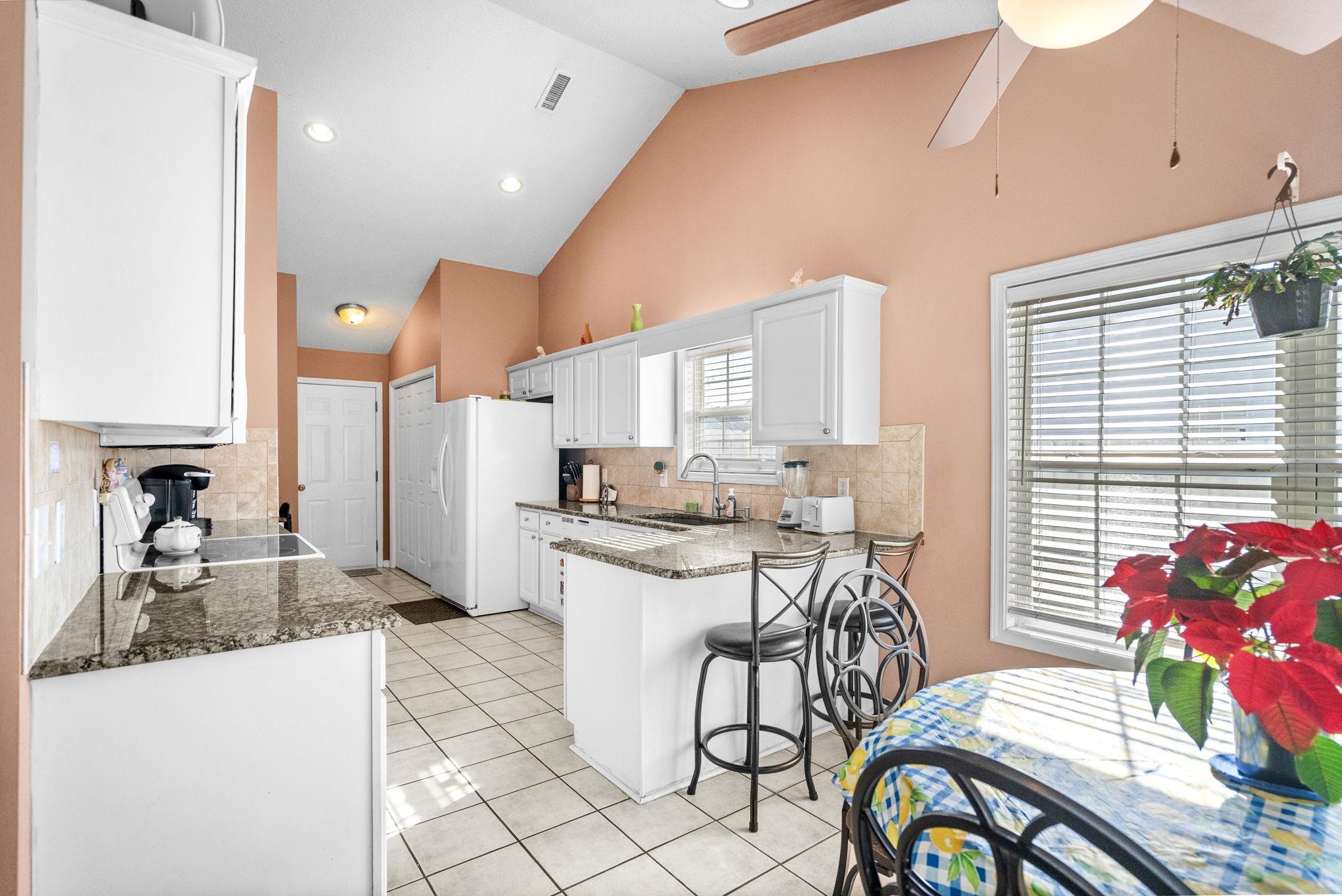 120 Point Break Drive Myrtle Beach, SC 29588 - Photo 17 of 38 Kitchen with white cabinetry, high vaulted ceiling, a peninsula, a ceiling fan, and a breakfast bar