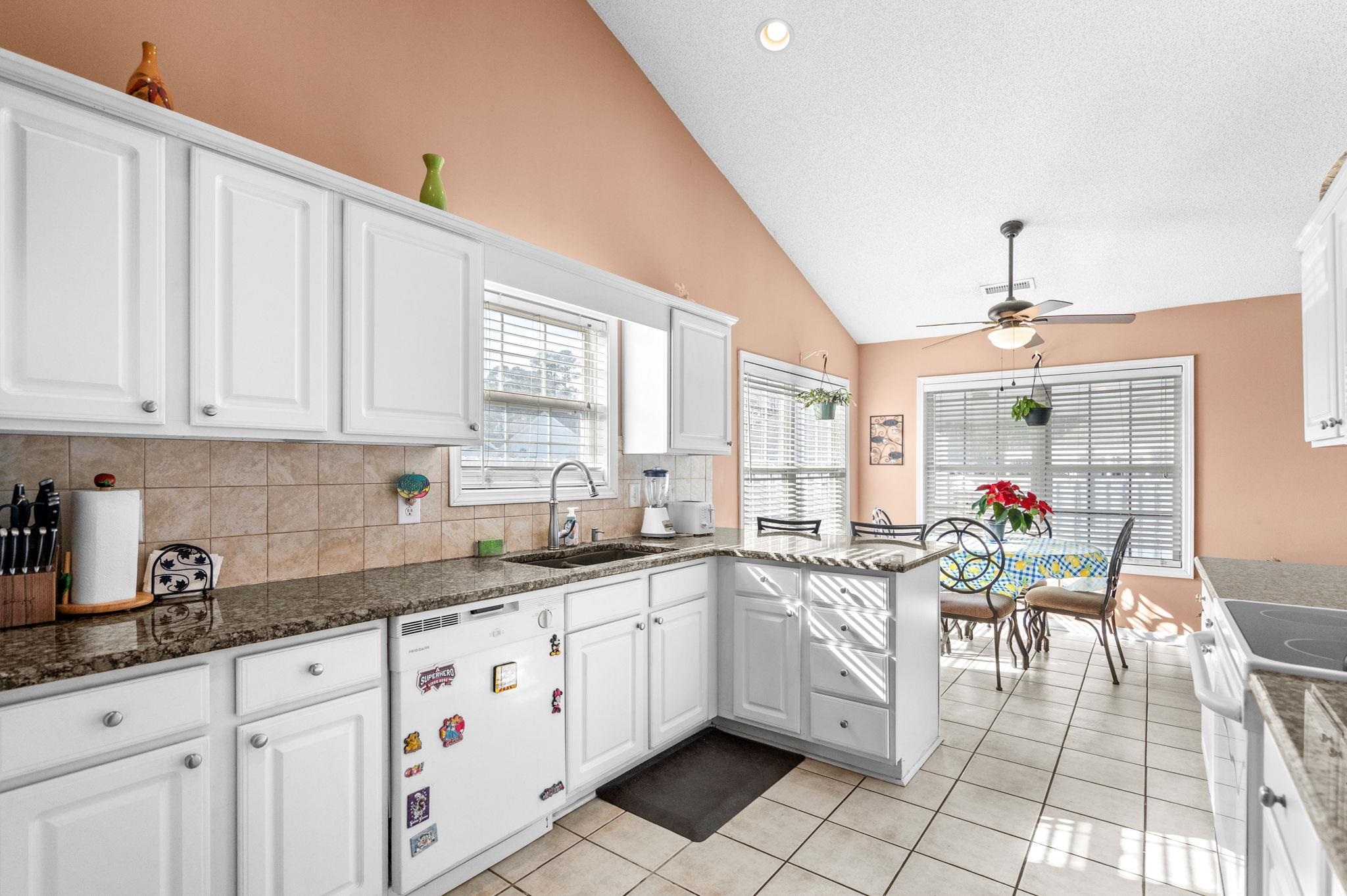 120 Point Break Drive Myrtle Beach, SC 29588 - Photo 22 of 38 Kitchen featuring white cabinetry, white appliances, a peninsula, light tile patterned flooring, and high vaulted ceiling