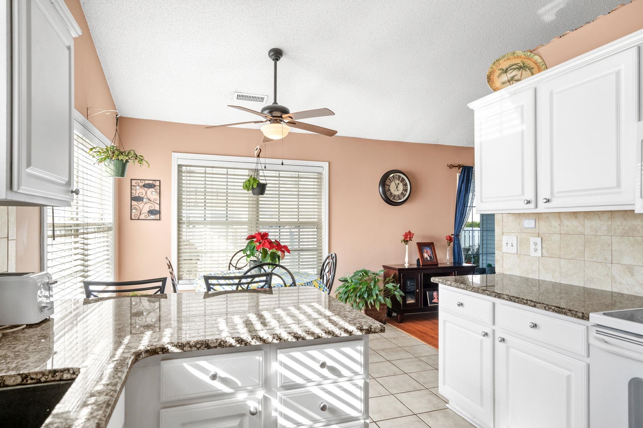 120 Point Break Drive Myrtle Beach, SC 29588 - Photo 23 of 38 Kitchen featuring decorative backsplash, dark stone countertops, light tile patterned floors, white cabinets, and electric stove