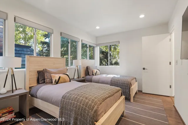 a bedroom with two beds and a large window