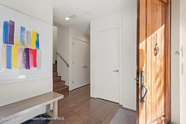a view of a bedroom with wooden floor and windows