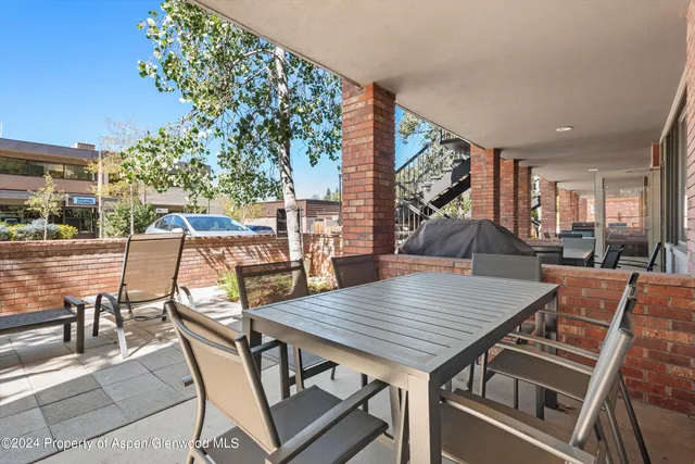 a view of a patio with table and chairs with wooden floor and fence