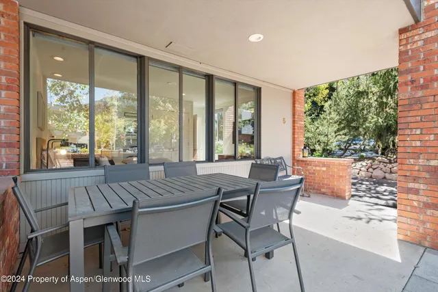 a view of a dining room with furniture large windows and wooden floor