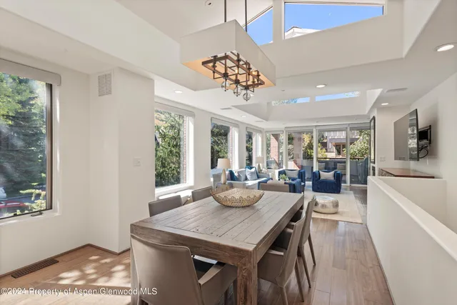 a view of a dining room with furniture a chandelier and wooden floor