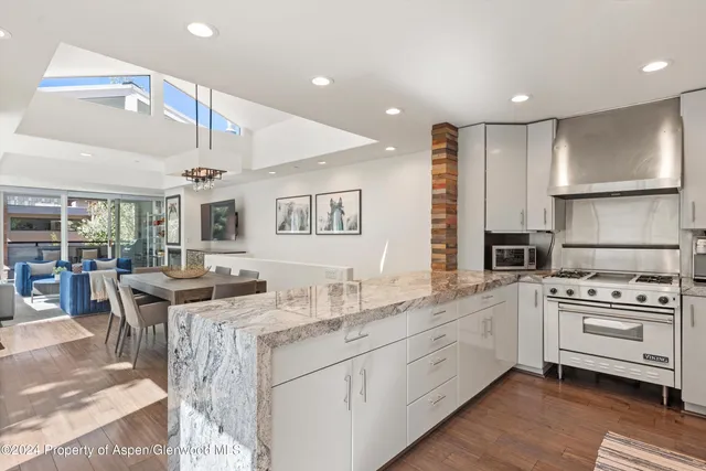 a kitchen with stainless steel appliances granite countertop a sink and cabinets