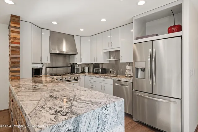 a kitchen with stainless steel appliances a refrigerator sink and microwave