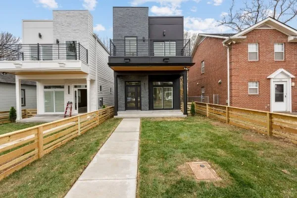 a view of a white house with large windows and a yard