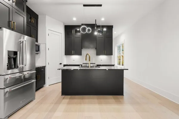 a kitchen with granite countertop a refrigerator and a stove top oven