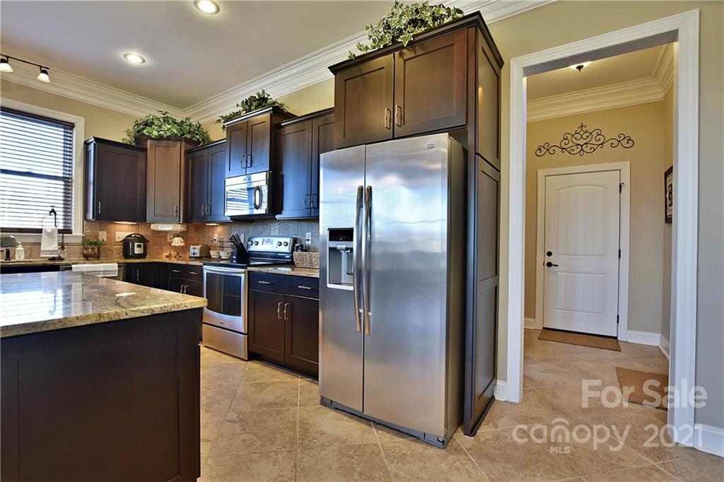 3822 Zebulon Williams Road Monroe, NC 28110 - Photo 11 of 36 a kitchen with stainless steel appliances granite countertop a refrigerator a sink and a stove