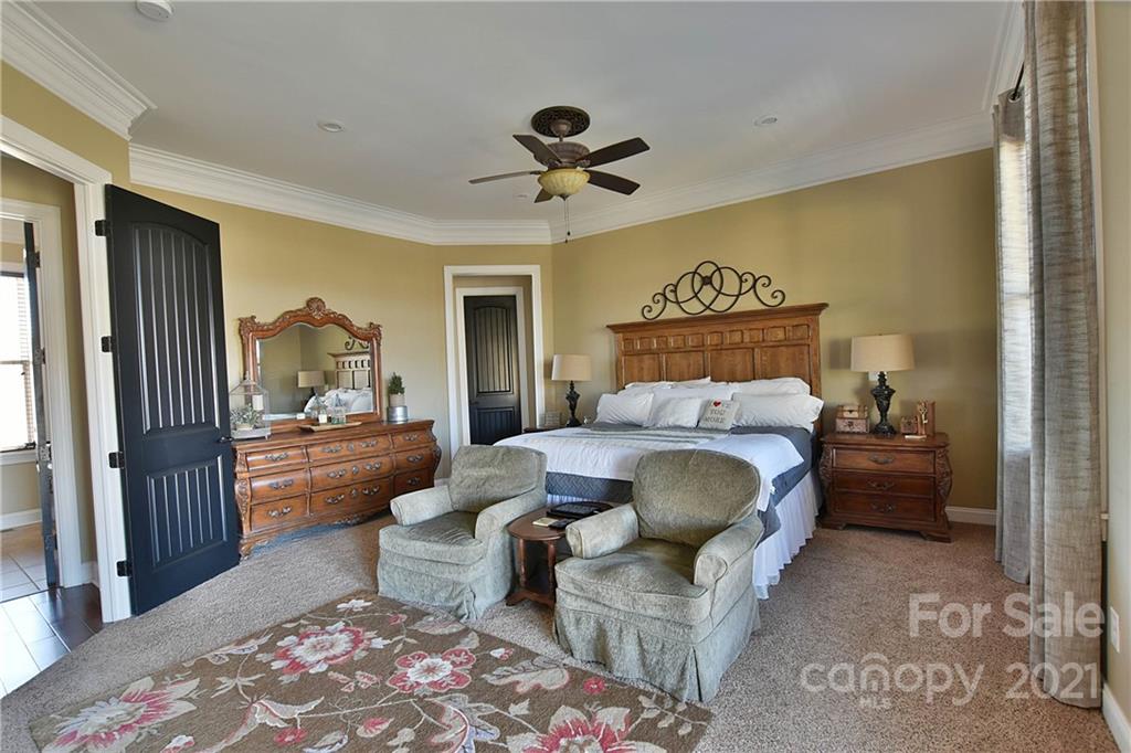 3822 Zebulon Williams Road Monroe, NC 28110 - Photo 13 of 36 a bedroom with a large bed and a chandelier