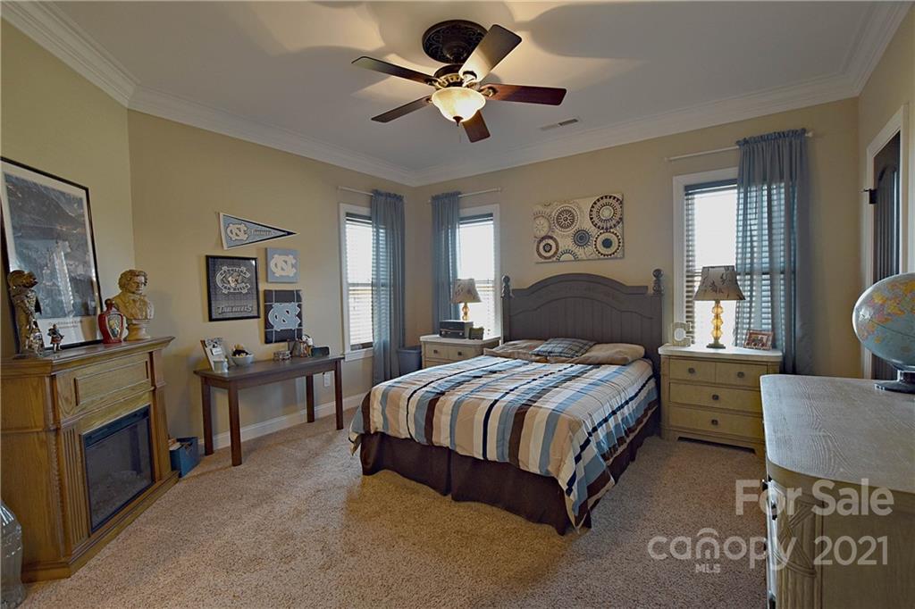 3822 Zebulon Williams Road Monroe, NC 28110 - Photo 21 of 36 a bedroom with a bed and a chandelier