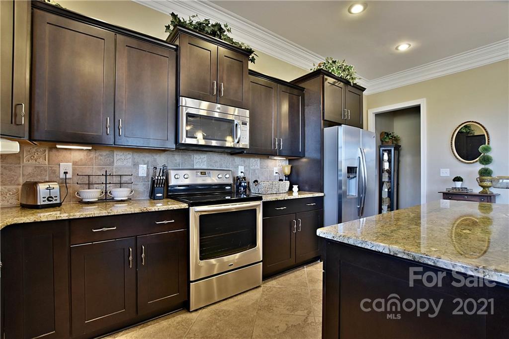 3822 Zebulon Williams Road Monroe, NC 28110 - Photo 10 of 36 a kitchen with granite countertop a sink cabinets and stainless steel appliances